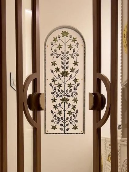 The doors to this pooja room are a work of art. The intricate floral inlay work on the glass panel allows light to filter through while maintaining a sense of privacy and sanctity for the sacred space within.
