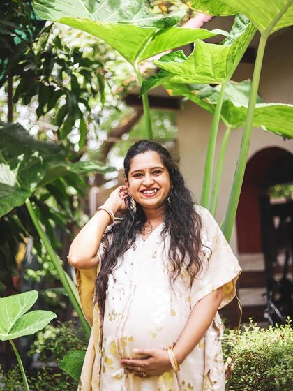 Using the large, dramatic leaves of the garden as a natural frame, this solo portrait feels both grand and intimate. The mother-to-be's gentle smile and pose create a beautiful image of tranquility and maternal grace.