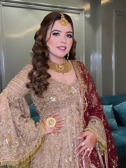A full-length portrait of my sister in a beautiful golden sharara suit. The makeup is soft glam, perfect for a wedding party.