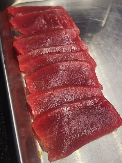 Slices of high-quality Bluefin tuna, ready for a tartare or to be lightly seared. The deep red color indicates its freshness and quality.