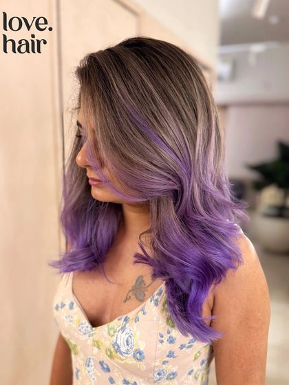 A candid shot of the ash brown and purple balayage, showing off the client's tattoo and the edgy vibe of the hair.