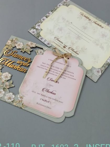 A beautiful invitation with a laser-cut floral frame and the couple's names in a gold cutout. The main insert is shaped and tied with a ribbon for an elegant presentation.