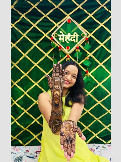 Pooja happily showing both her hands, covered in my intricate designs.