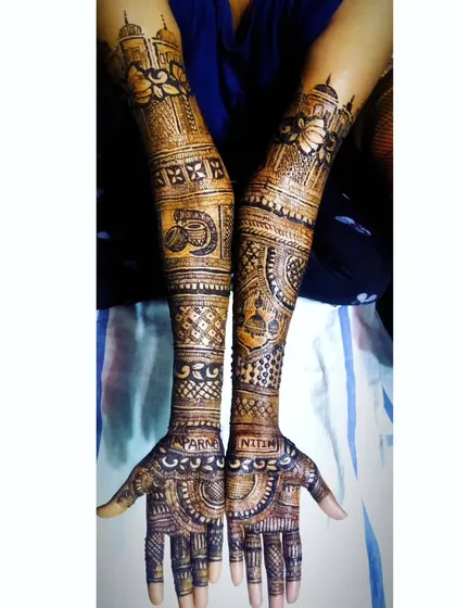 A personalized bridal design with the names 'Aparna' and 'Nitin' on the palms. The arms are decorated with a mix of floral, geometric, and traditional Indian motifs.
