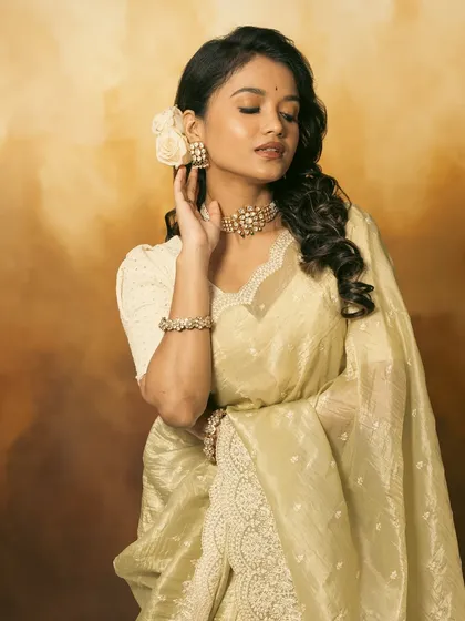 A beautiful side profile, showing the floral hair accessory and the elegant line of the choker.