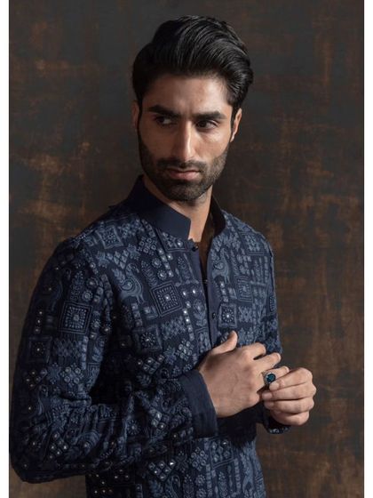 A detailed shot of the navy blue kurta, showing the fine embroidery and mirror work. This level of detail is what makes a bespoke garment truly special.