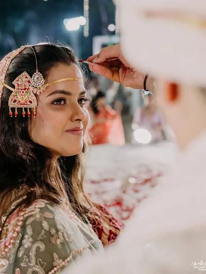 The intimate moment of applying the sindoor. It's these quiet, meaningful rituals that form the soul of the wedding day, and I ensure the setting is worthy of them.