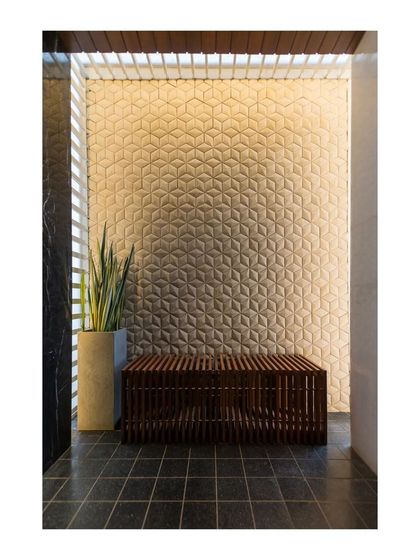 This quiet nook in the home features a stunning 3D geometric tile wall that creates a beautiful play of light and shadow. Paired with a simple slatted wood bench, it becomes a small, contemplative space.