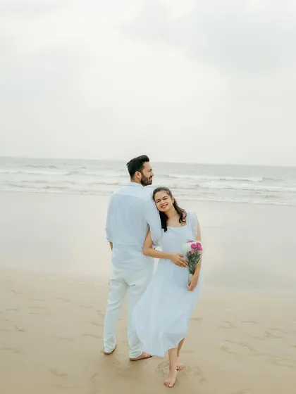 A sweet and gentle portrait on the beach, with the bride leaning against the groom, looking peacefully at the camera.