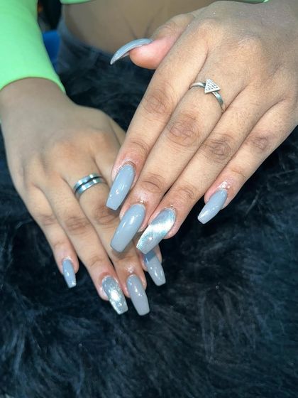 A simple yet chic set of solid grey nails with a silver chrome accent. This shows how to use accent nails to add interest to a monochrome set.