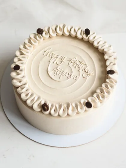 A simple and elegant Chocolate Mocha Caramel cake, personalized for a birthday celebration. The smooth coffee-infused frosting is complemented by delicate piping and a few coffee beans for a classic finish.