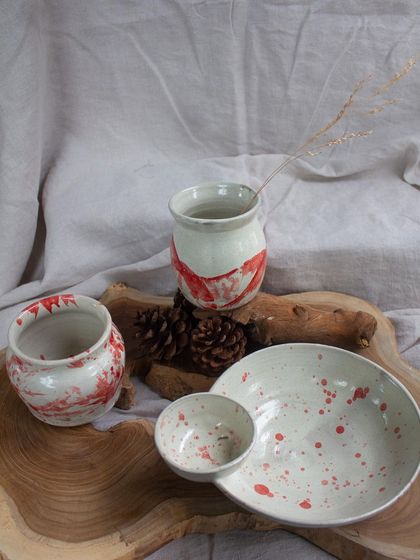 More student work with red and white marbled patterns, including vases and bowls.