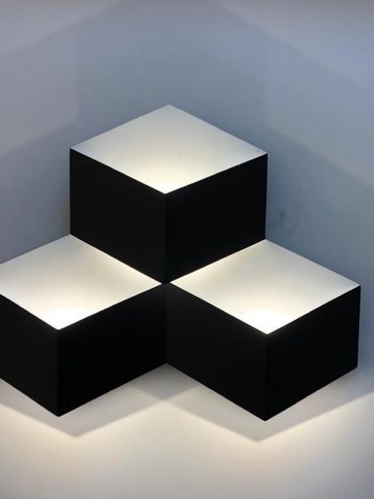 A geometric, cube-like wall light that plays with perspective and creates a 3D effect with its illumination.