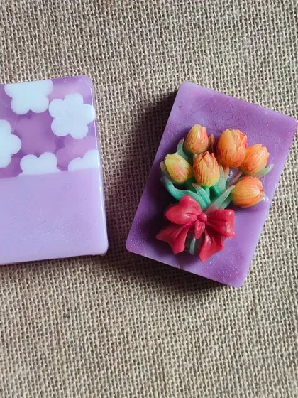 Two beautiful lavender-themed soaps, one with a cloud pattern and the other with a bouquet of tulips.