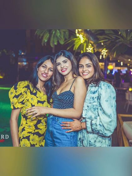 More happy faces from the Seven Rivers party. The outdoor setting with fairy lights creates a magical atmosphere.