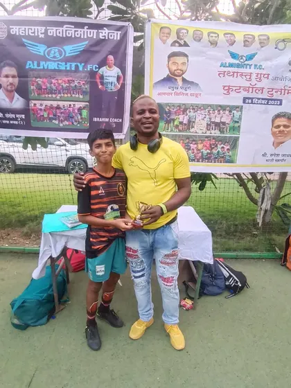 A player proudly accepts his award from the coach after a great tournament.