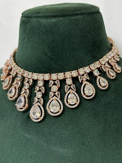 A close-up of a rose-gold plated American diamond choker. The warm tone of the metal gives this rental piece a unique and modern feel.