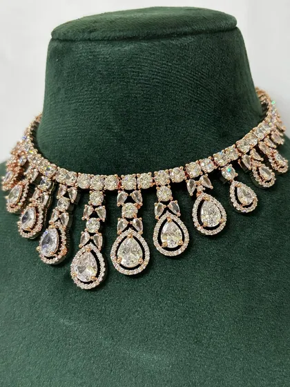 A close-up of a rose-gold plated American diamond choker. The warm tone of the metal gives this rental piece a unique and modern feel.