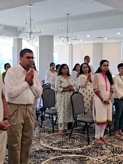 Participants stand in prayer during our satsang in the USA. Moments of collective prayer and intention-setting are an integral part of our programs.