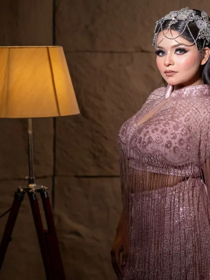 A side profile of the model in the pink fringe gown, highlighting the elegant silhouette.