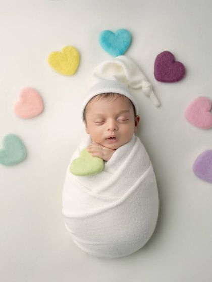 Surrounded by hearts. A simple, sweet portrait of a newborn wrapped in white, expressing all the love for this new arrival.