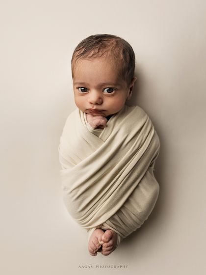 A similar "potato sack" wrap pose, but this time with the baby awake and making a curious expression. I always follow the baby's lead, capturing both sleepy and awake moments.