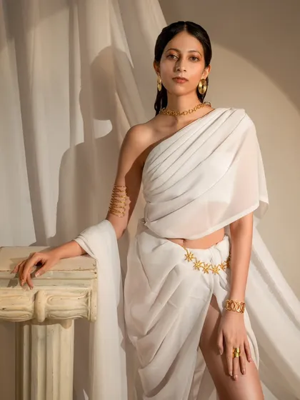 A direct, powerful portrait from the Grecian series. The one-shoulder drape and gold jewelry are highlighted by soft, directional lighting, creating a look of modern divinity.