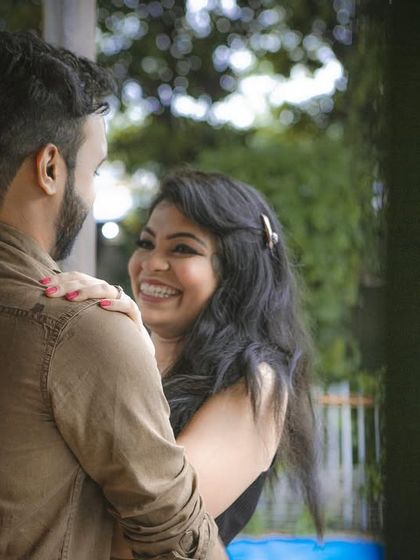 A candid and joyful pre-wedding photo capturing a genuine moment of laughter and affection between the couple.