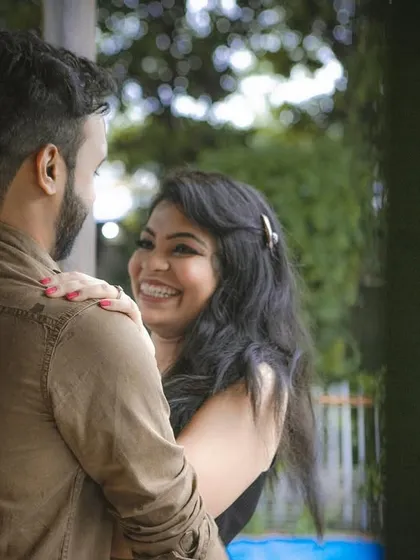 A candid and joyful pre-wedding photo capturing a genuine moment of laughter and affection between the couple.