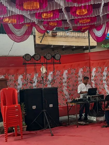 A clear shot of my DJ setup at an outdoor event. You can see the speakers, lighting truss, and my console, all set up and ready to bring the party to life.