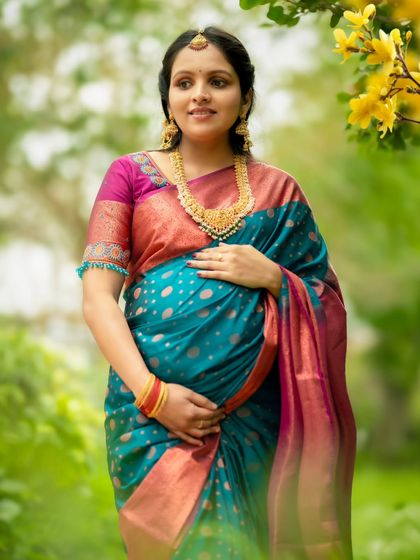 A beautiful solo portrait of the mom-to-be standing among yellow flowers, her traditional attire glowing in the natural light.
