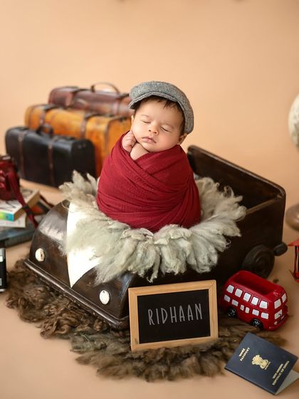 The complete traveler setup for Ridhaan, featuring vintage luggage, a globe, a passport, and his name on a little slate.