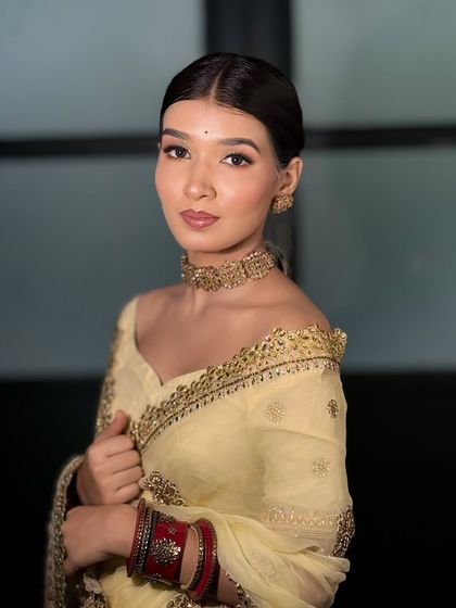 A classic portrait of the bride in the yellow saree. Her makeup is minimal and elegant, letting her natural beauty shine through.