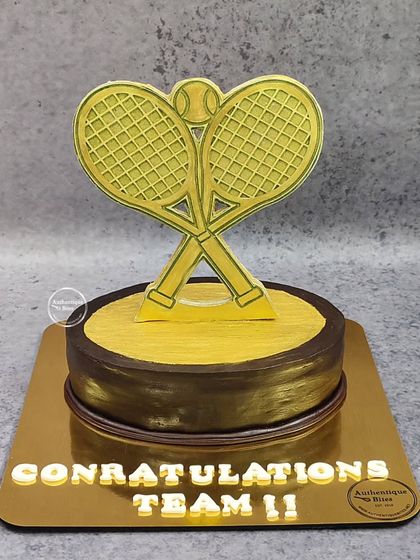 We created this special trophy cake for the Delhi Club Tennis Championships. The design features a golden tennis racket trophy on a chocolate and gold base.