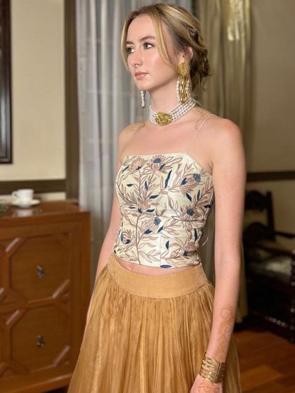 A three-quarter view of the sister of the bride, showcasing her elegant pearl choker and earrings. The makeup is kept minimal and fresh to complement the statement jewellery.