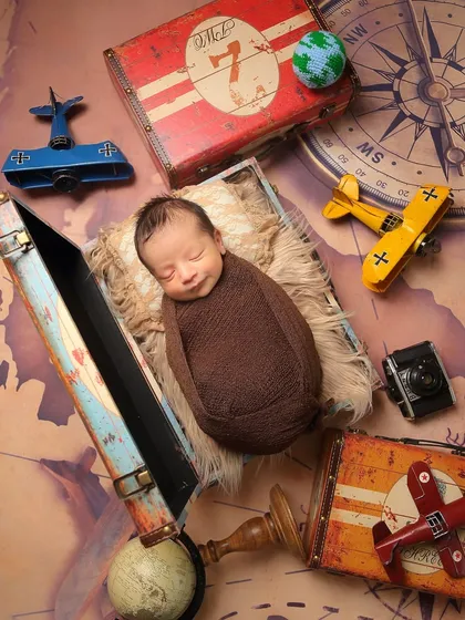 An overhead view of the travel-themed setup. This angle shows all the fun details, from the map backdrop to the vintage props surrounding the peacefully sleeping baby.
