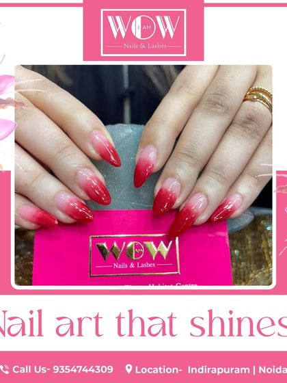 A bold and fiery red ombré on long, stiletto nails. The color fades from a sheer nude to a vibrant, glossy red at the tips for a dramatic effect.