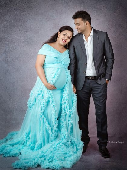 A sweet couple portrait featuring a lovely sky-blue ruffled gown. The partner's formal suit complements the elegance of the dress perfectly.