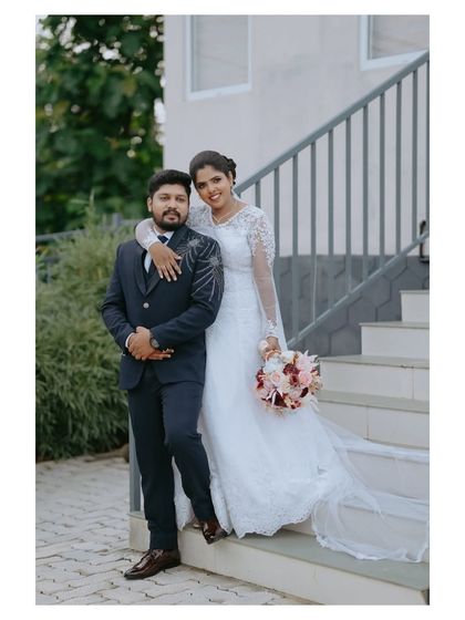 A classic wedding pose with the bride embracing the groom from behind. This type of portrait is perfect for showcasing the couple's bond and their wedding attire.