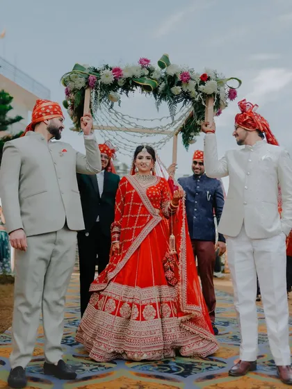 The bride's grand entrance under a beautiful phoolon ki chadar held by her brothers, a traditional and emotional moment we love to document.
