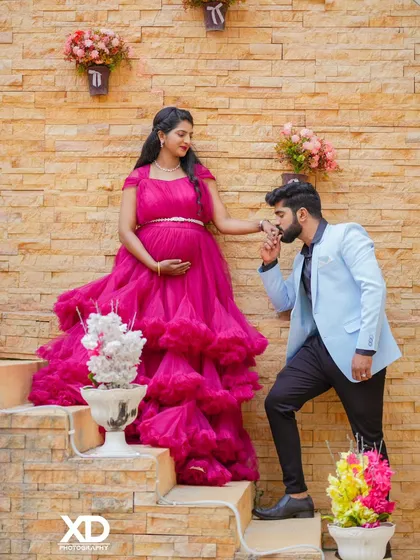 A chivalrous pose with the partner kissing the mother-to-be's hand on a rustic staircase.