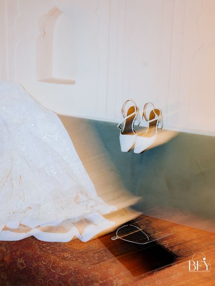 An artistic, motion-blur shot of a bride's shoes and lehenga, a fine-art detail from an engagement shoot.