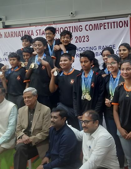 The Eminent Shooting Hub team celebrating with officials after a successful medal haul at the 11th Karnataka State Shooting Competition.