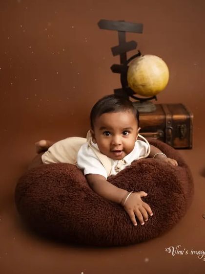 Ready to explore the world. This infant portrait uses a travel theme with a globe, vintage suitcase, and a miniature airplane to capture a sense of adventure.