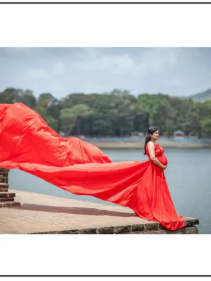 A stunning solo shot by the lake, with the wind catching the dramatic red gown.