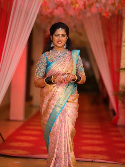 A full-length shot of Rashmi's reception attire. The combination of the embroidered blouse and silk saree is both traditional and chic.