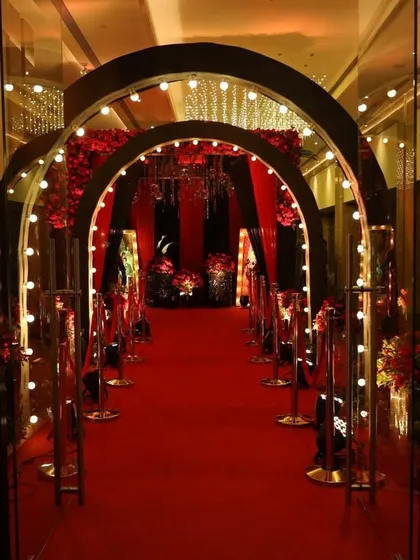 The entrance to a glamorous Bollywood-themed sangeet night. I used a red carpet, arched doorways with bulb lights, and rich red drapes to create the feeling of a grand movie premiere.