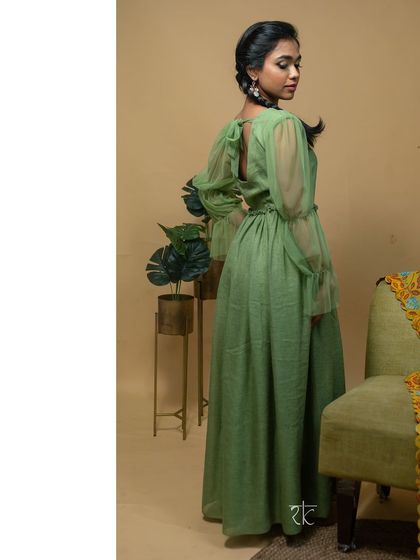 The dress features a tie-back detail and romantic sheer net sleeves, combining comfort with high style.