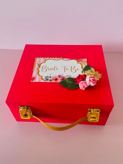 The outside of the "Bride to be" hamper, featuring a beautiful custom tag. This red suitcase box is perfect for celebrating the special milestone.