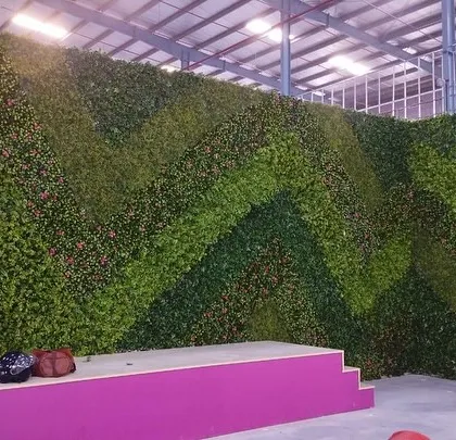 Another angle of the chevron-patterned green wall, showing its three-dimensional quality and impressive scale in a warehouse setting.